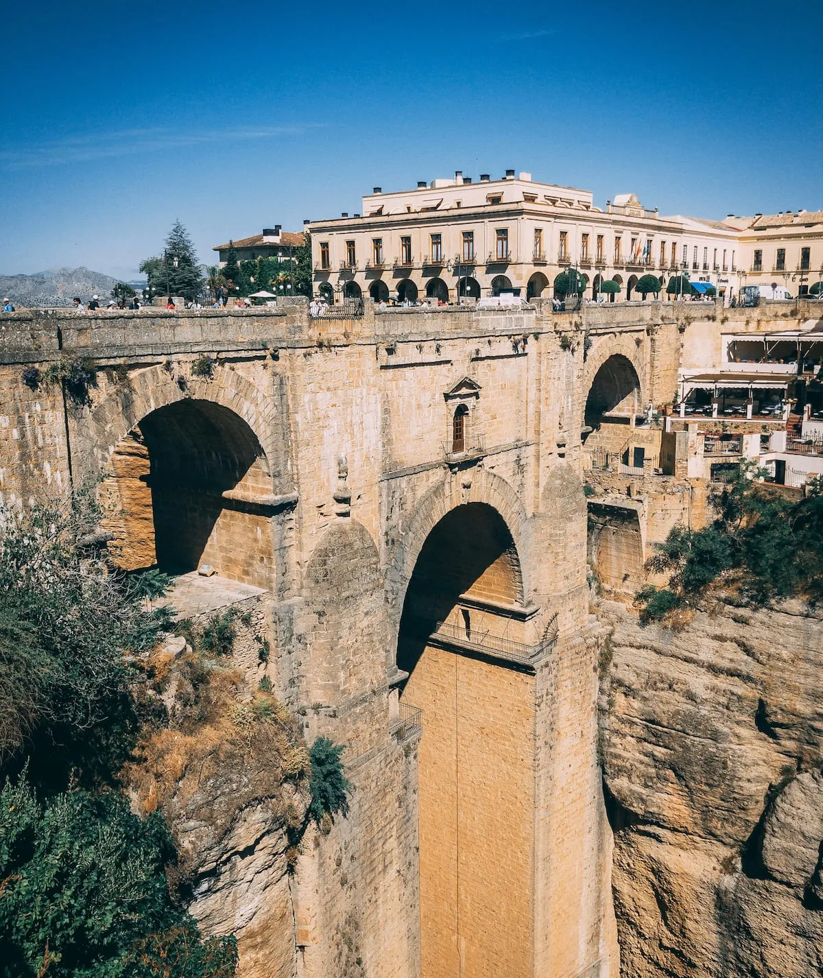 El Puente Nuevo de Ronda y su arco central sobre el Tajo, con el Parador de Ronda detrás, en la Plaza de España